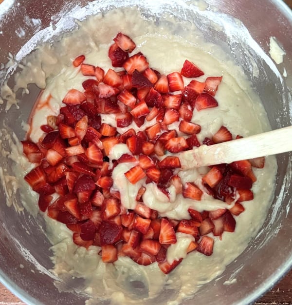 Sliced strawberries mixed into cake batter.