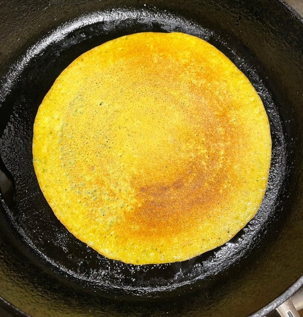 Cooked adai on skillet.