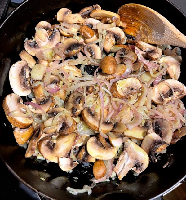 Mushrooms and onions in cast iron griddle.