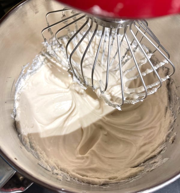 Cheesecake batter mixing in stand mixer bowl.