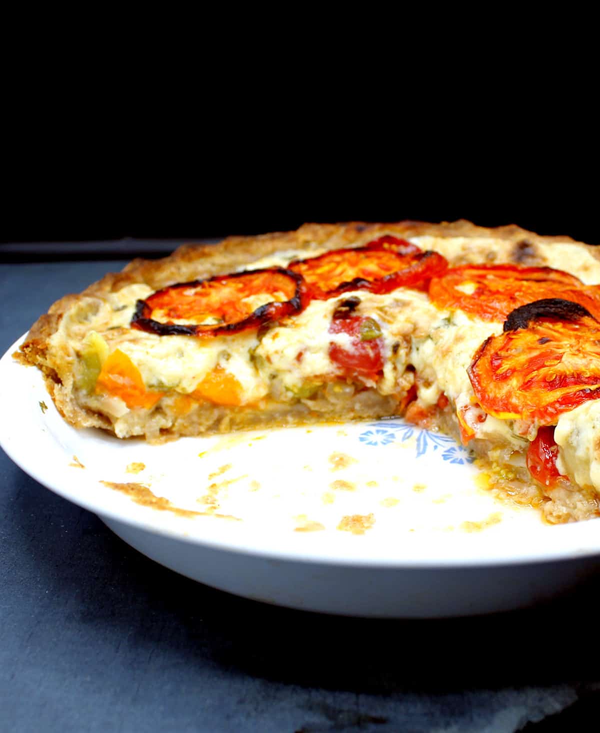 Photo showing a cross section of a vegan tomato pie with a gooey mayo-cheese filling.