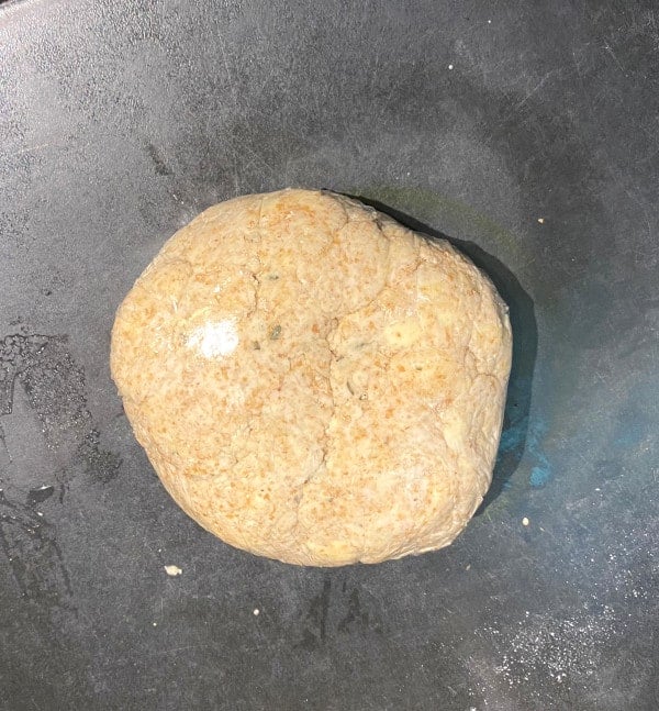 Vegan whole wheat crust dough ball on gray surface.