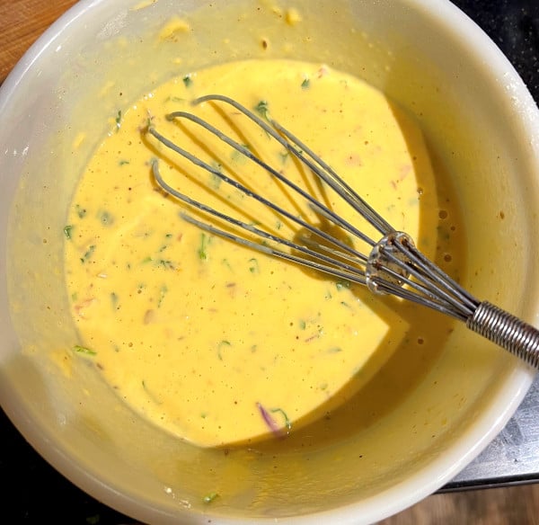 Batter for ros omelet in bowl with whisk