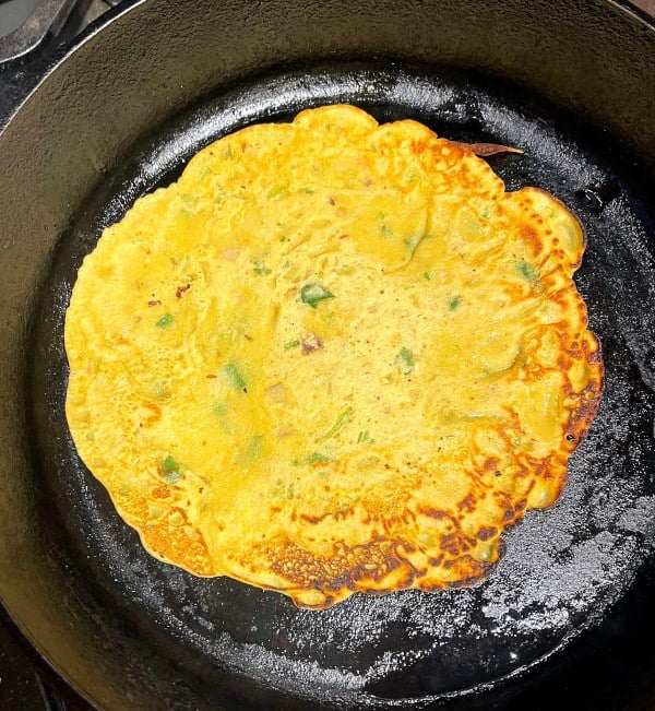 Vegan omelet for ros omelette cooking on cast iron griddle