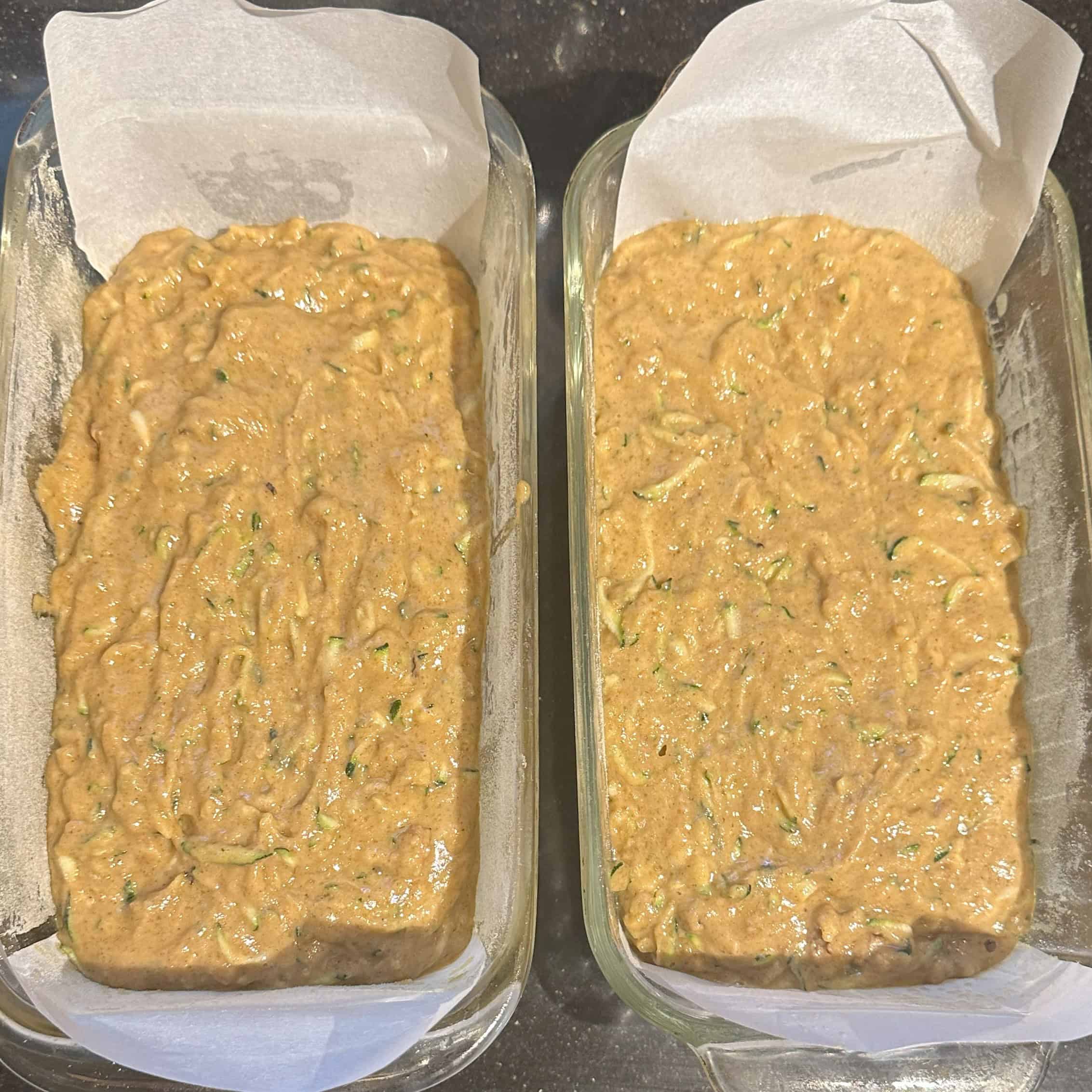 Zucchini bread batter in two loaf pans ready for baking.