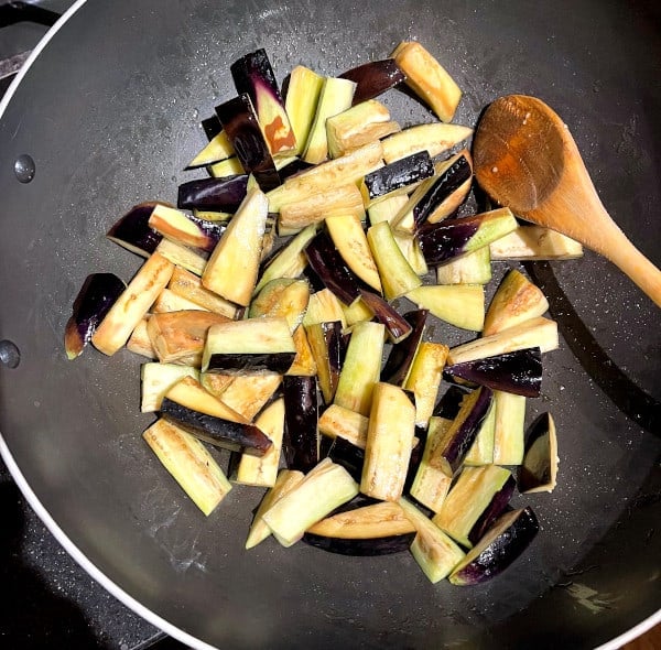 Eggplant slices frying in wok.