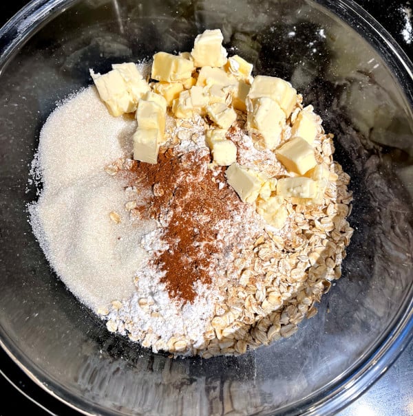Ingredients for crisp topping in bowl, including sugar, butter, cinnamon, nutmeg and oats