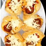 Crispy, golden vegan puff pastry cups with meatball marinara sauce on a white plate.