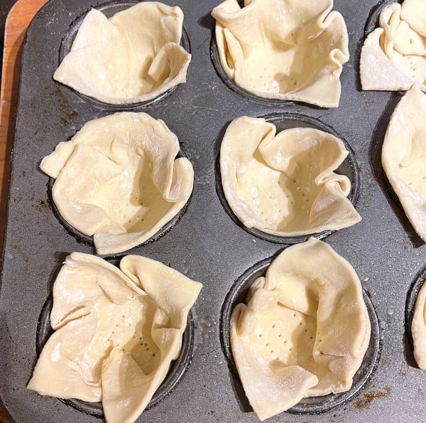 Puff pastry cups in muffin tins with bottoms docked