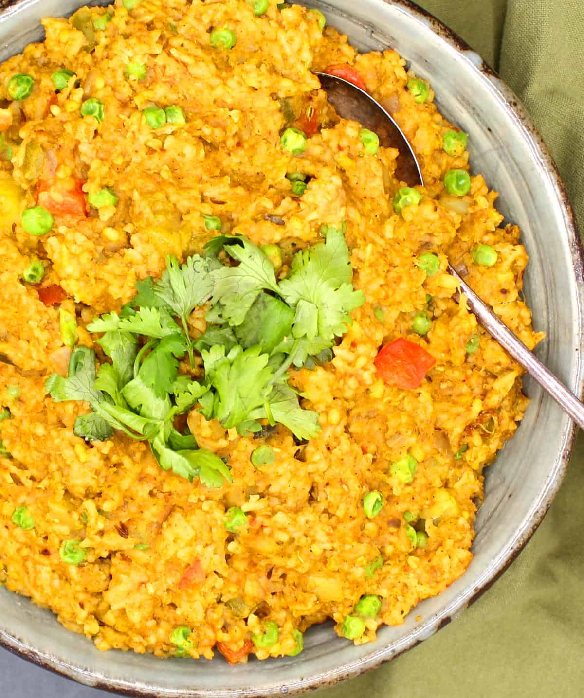 Closeup of masala khichdi in bowl with spoon.