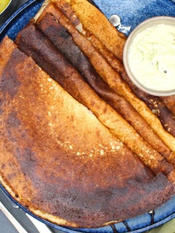 Quinoa dosa arranged on a serving plate with coconut chutney.