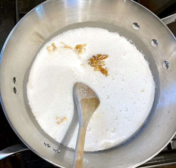 Cashew milk added to the pot with caramel