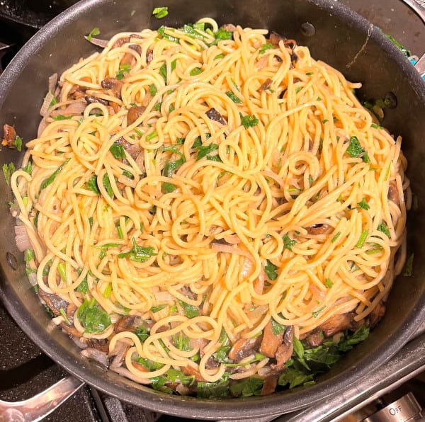 Saute pan with cooked mushroom pasta.