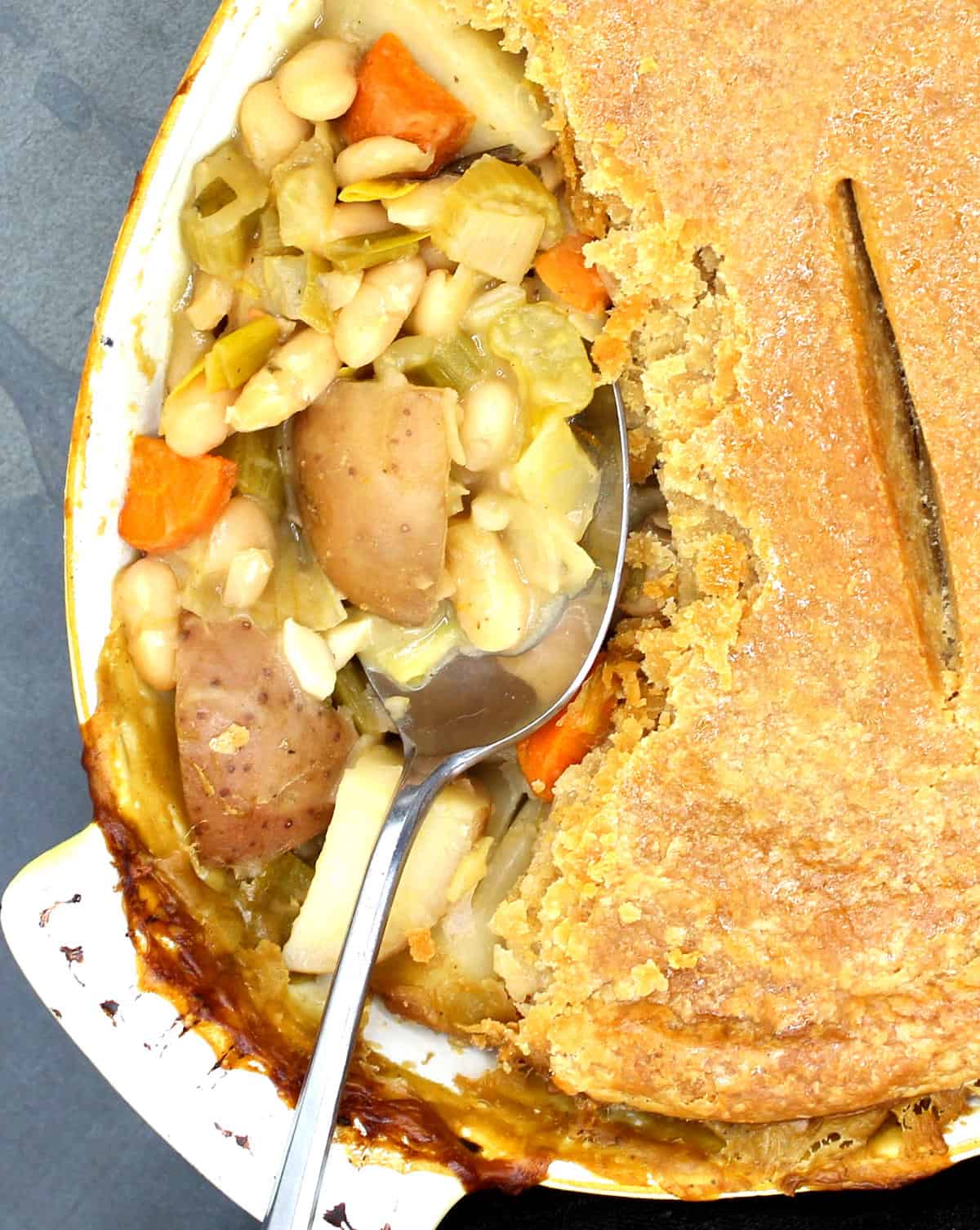 Closeup photo of a vegan bean potato pot pie showing the creamy veggie and bean filling.