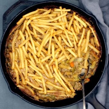 Vegan French fry casserole with a spoon.