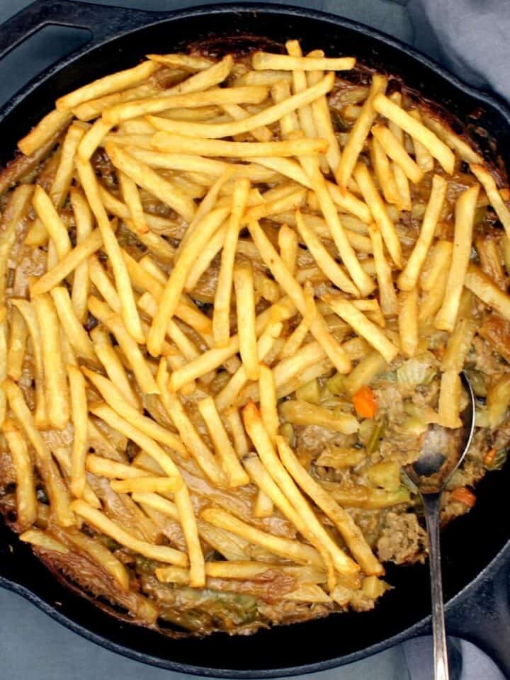 Vegan French fry casserole with a spoon.