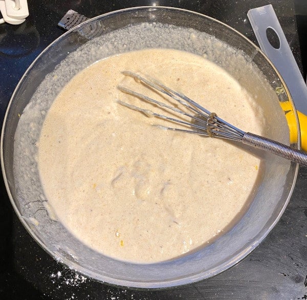 Lemon pancake batter mixed in bowl with whisk
