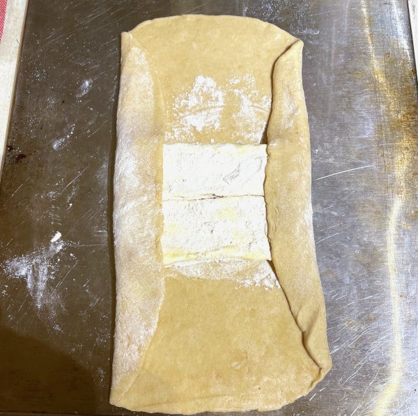 Folding of puff pastry over butter
