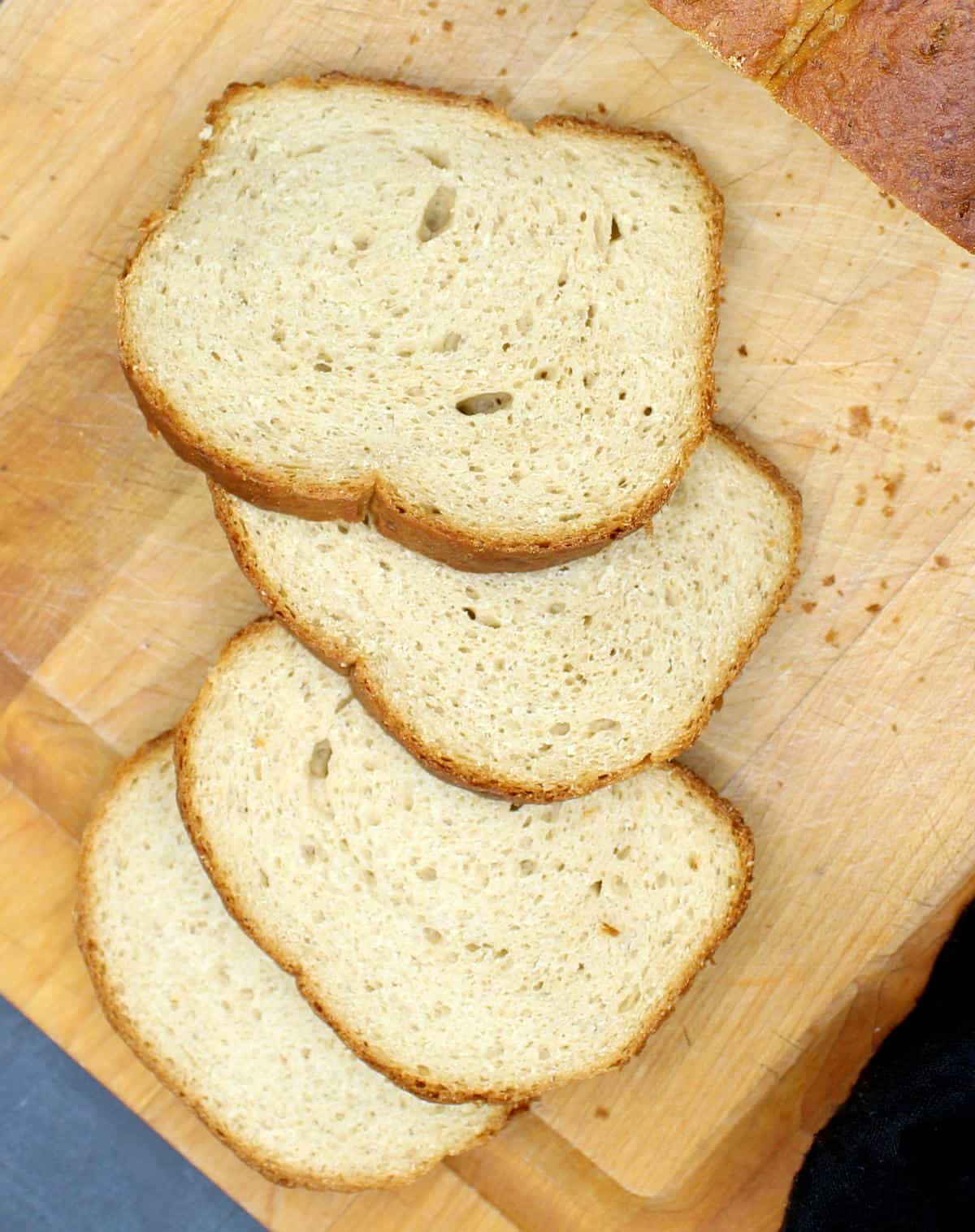 Flour slices of whole wheat sandwich bread on a chopping board.