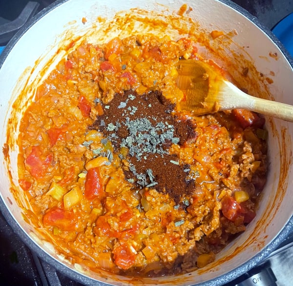 Chili powder, cumin, paprika and sage in pot.