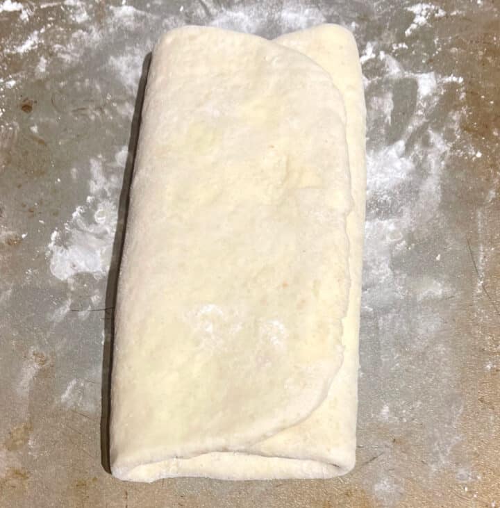 Folded vegan puff pastry crust on baking sheet.