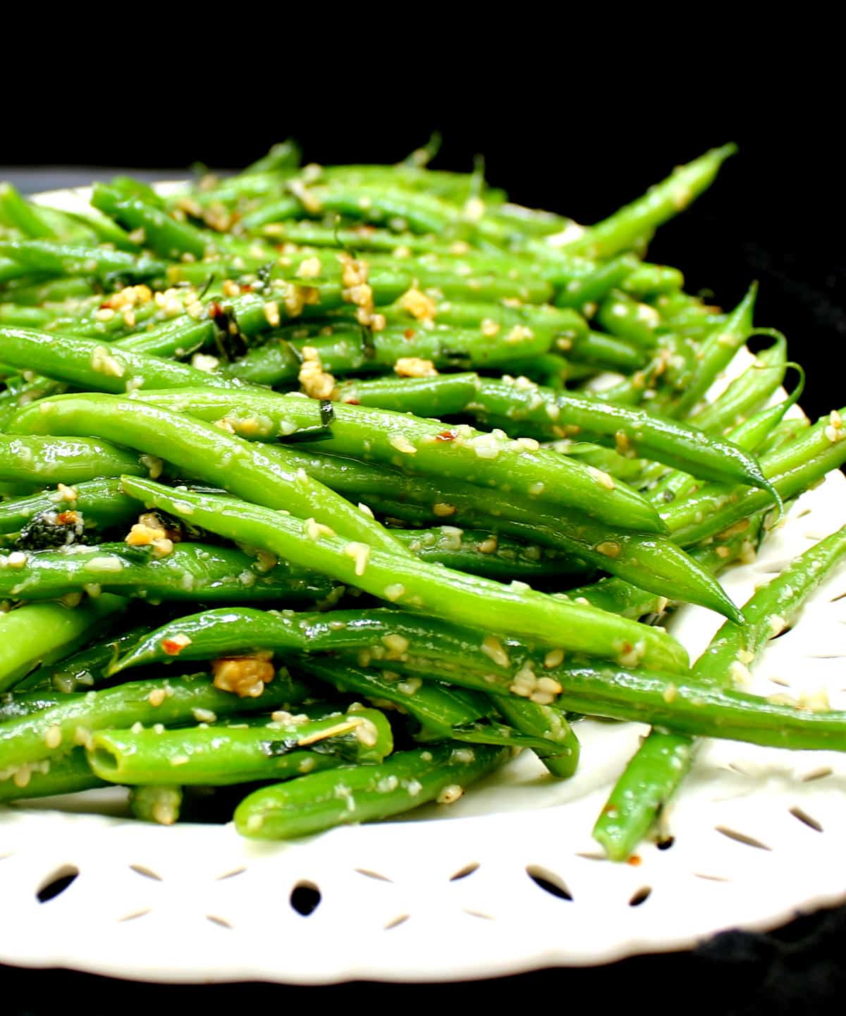 Front photo of garlic green beans on a white cutout platter.