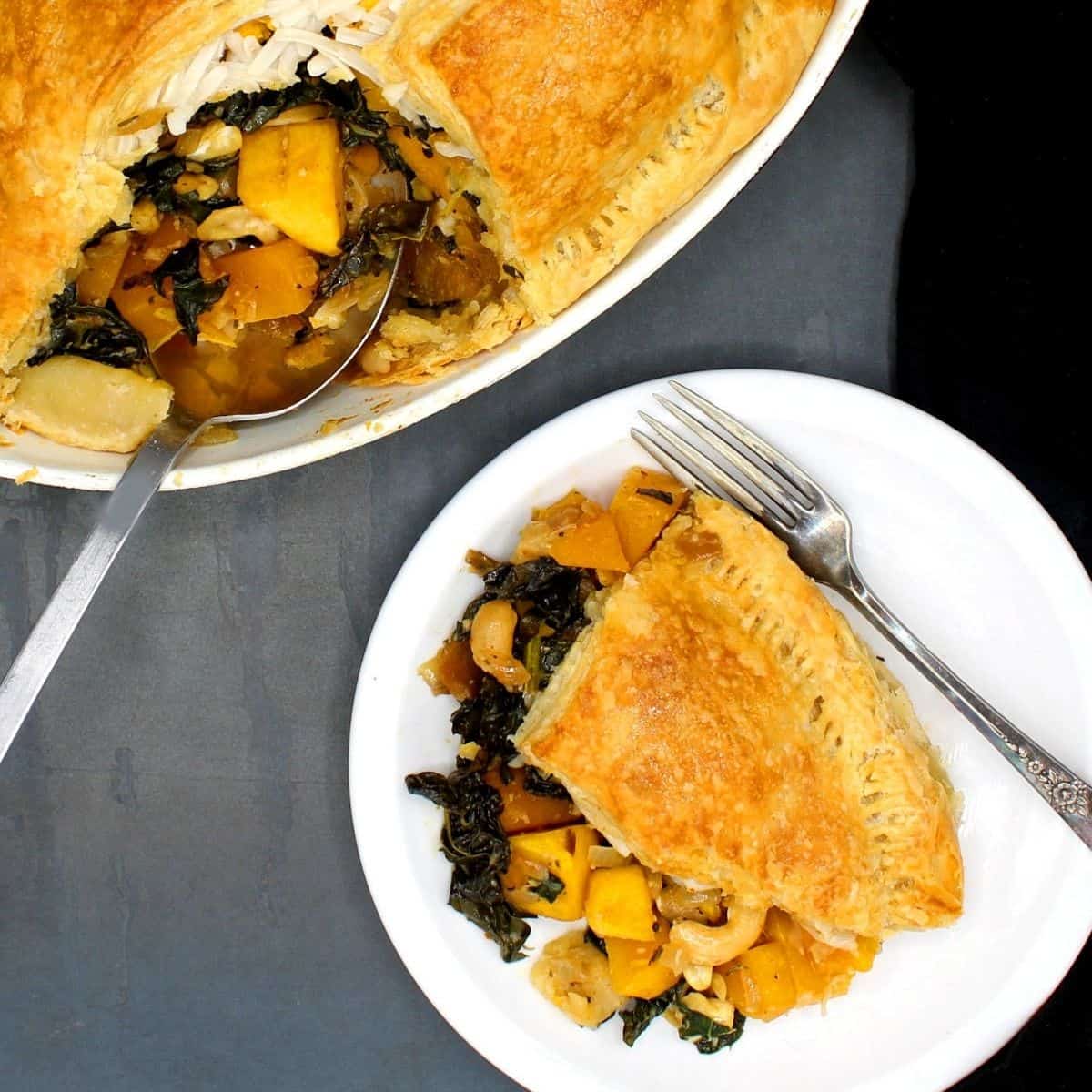 Overhead image of a slice of vegan butternut squash kale pie in white plate