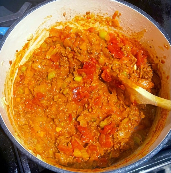 Tomatoes and tomato paste added to chili.