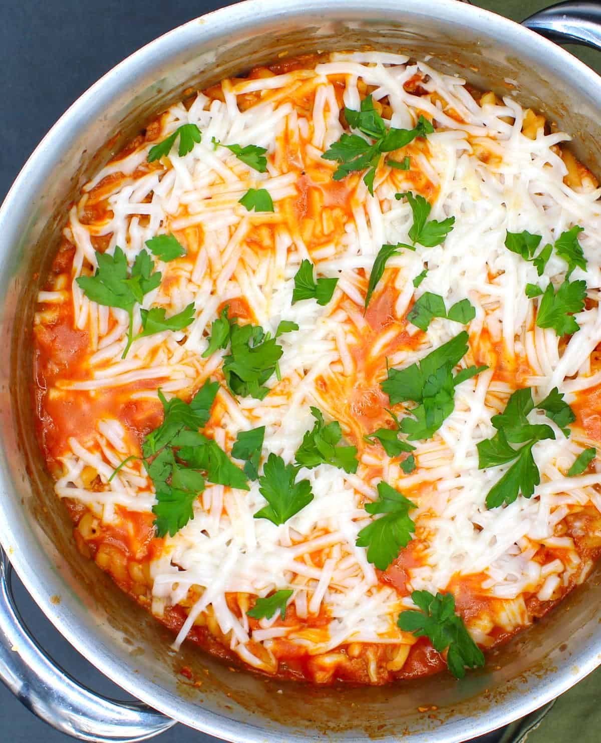 Overhead closeup of vegan one pot pasta with cheese and parsley.