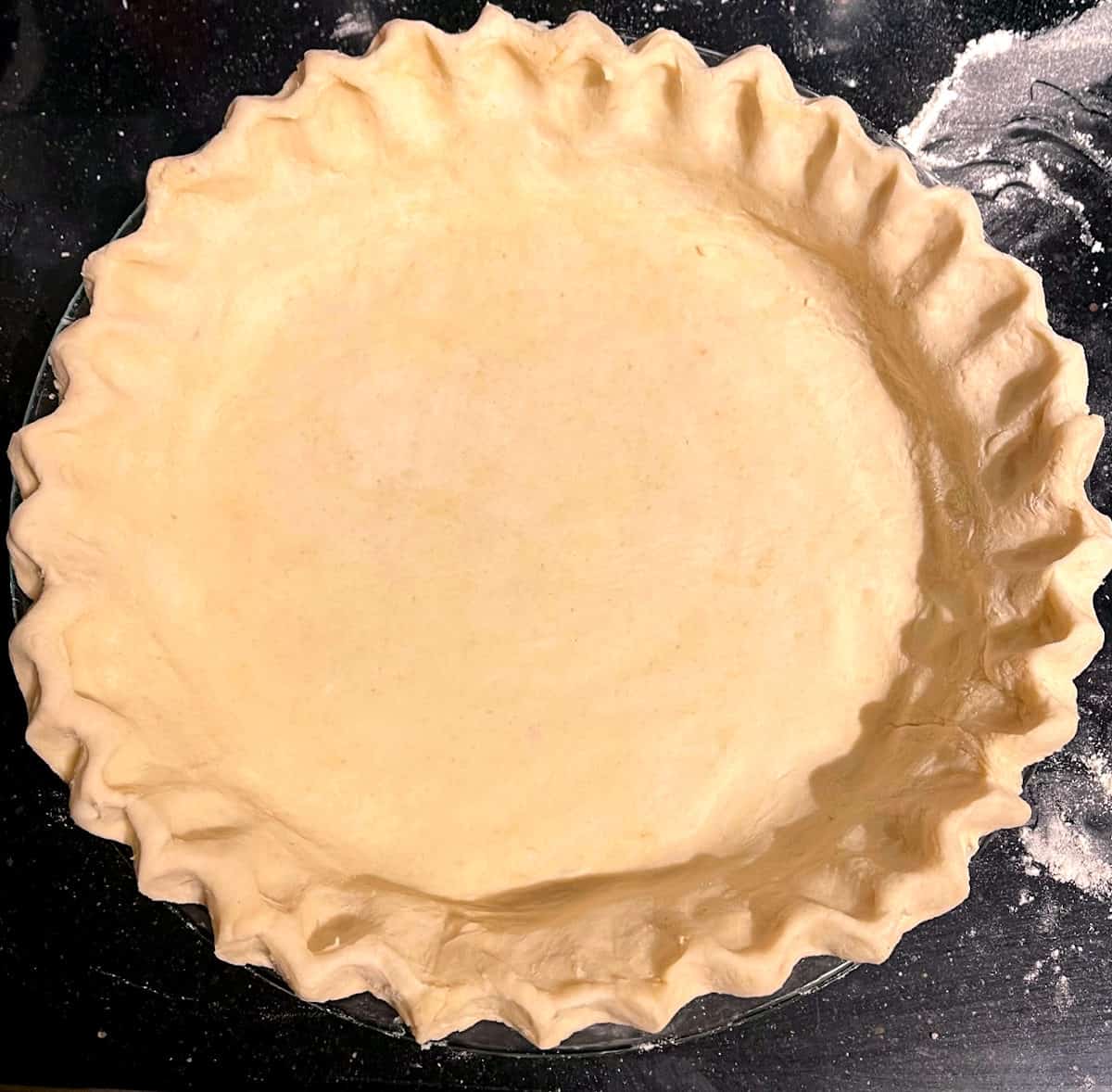 Overhead photo of an unbaked vegan pie crust in pie plate.