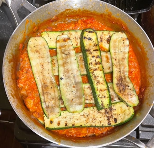 Zucchini slices layered over marinara.