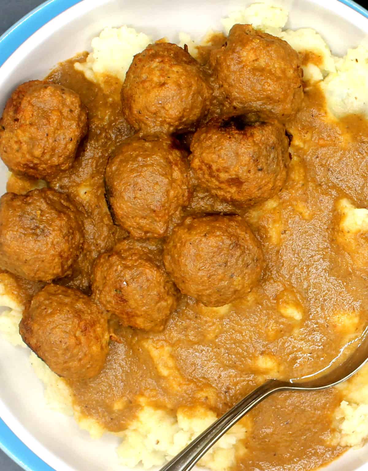 Closeup shot of vegan meatballs and mashed potatoes with delicious vegan gravy.