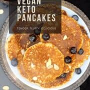 Image of pancakes on a blue plate with blueberries and sliced almonds with text inlay that says "vegan low-carb recipes, vegan keto pancakes, tender, fluffy and delicious"