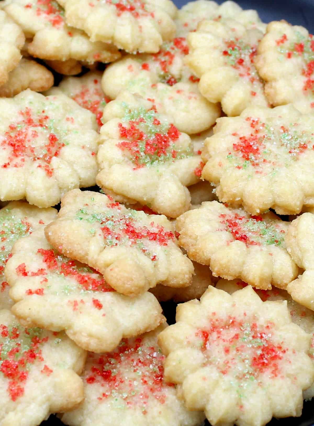 Closeup of vegan spritz cookies decorated with colored sugar sprinkles.