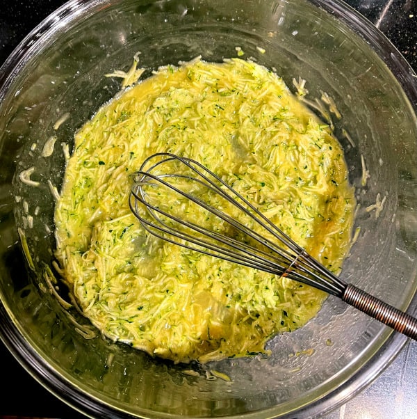 Zucchini mixed with butter and vanilla in bowl.