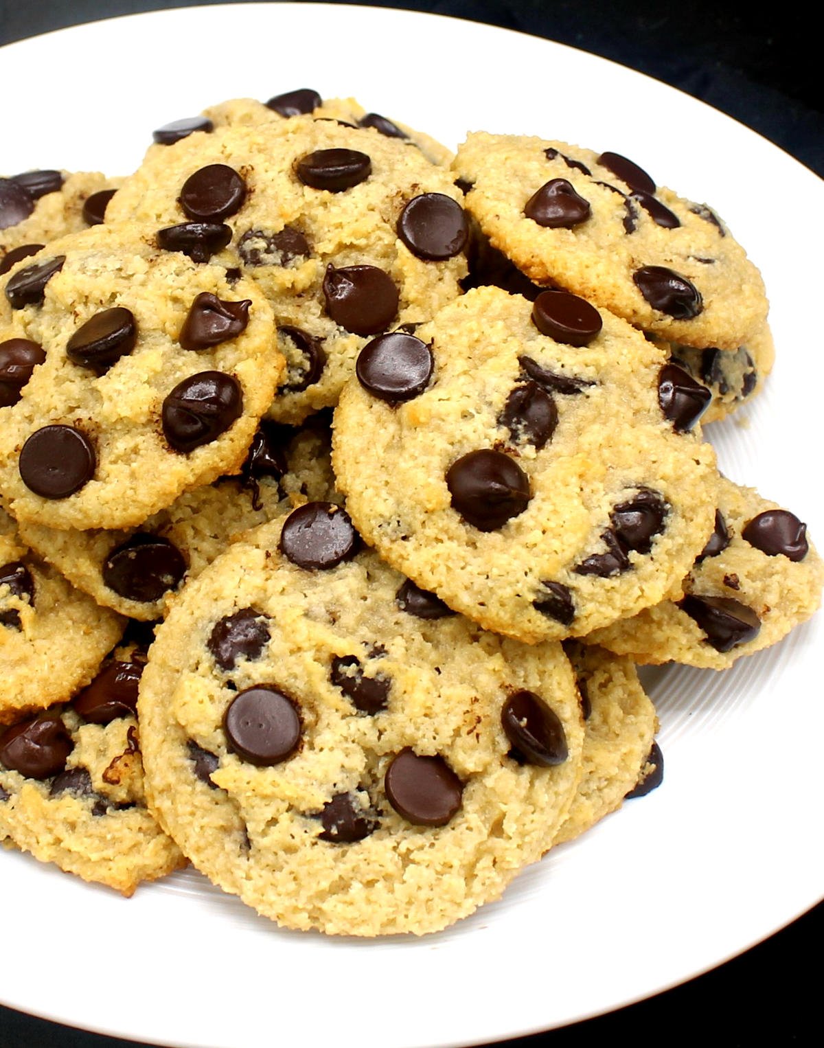 Front partial closeup of a white plate with vegan chocolate chip cookies with keto chocolate chips.