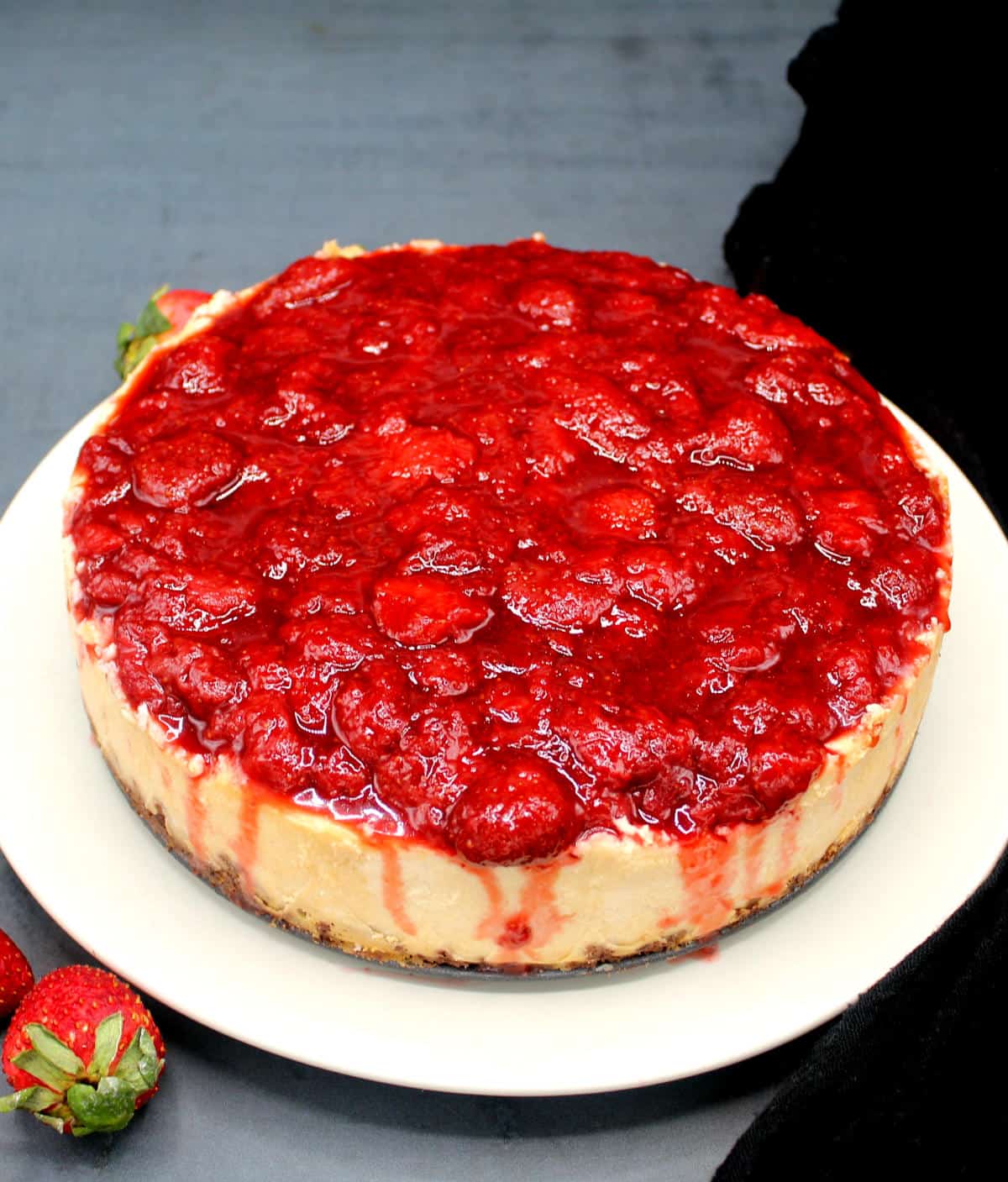 Front shot of a vegan low carb keto cheesecake with strawberry topping.