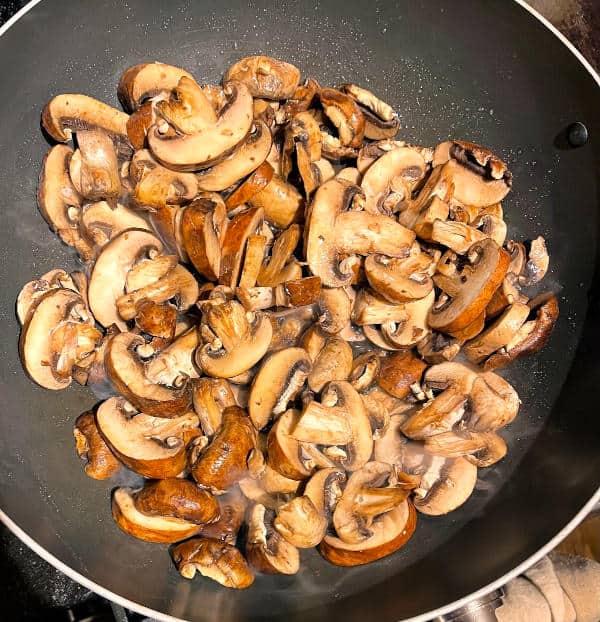 Mushrooms cooking in wok.