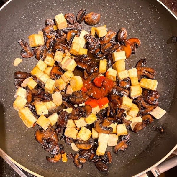 Tofu and sauce ingredients added to wok.