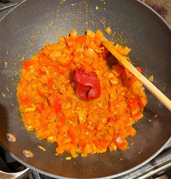 Tomato paste cooking in tomato onion sauce.