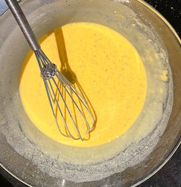 Chickpea flour batter whisked in bowl.