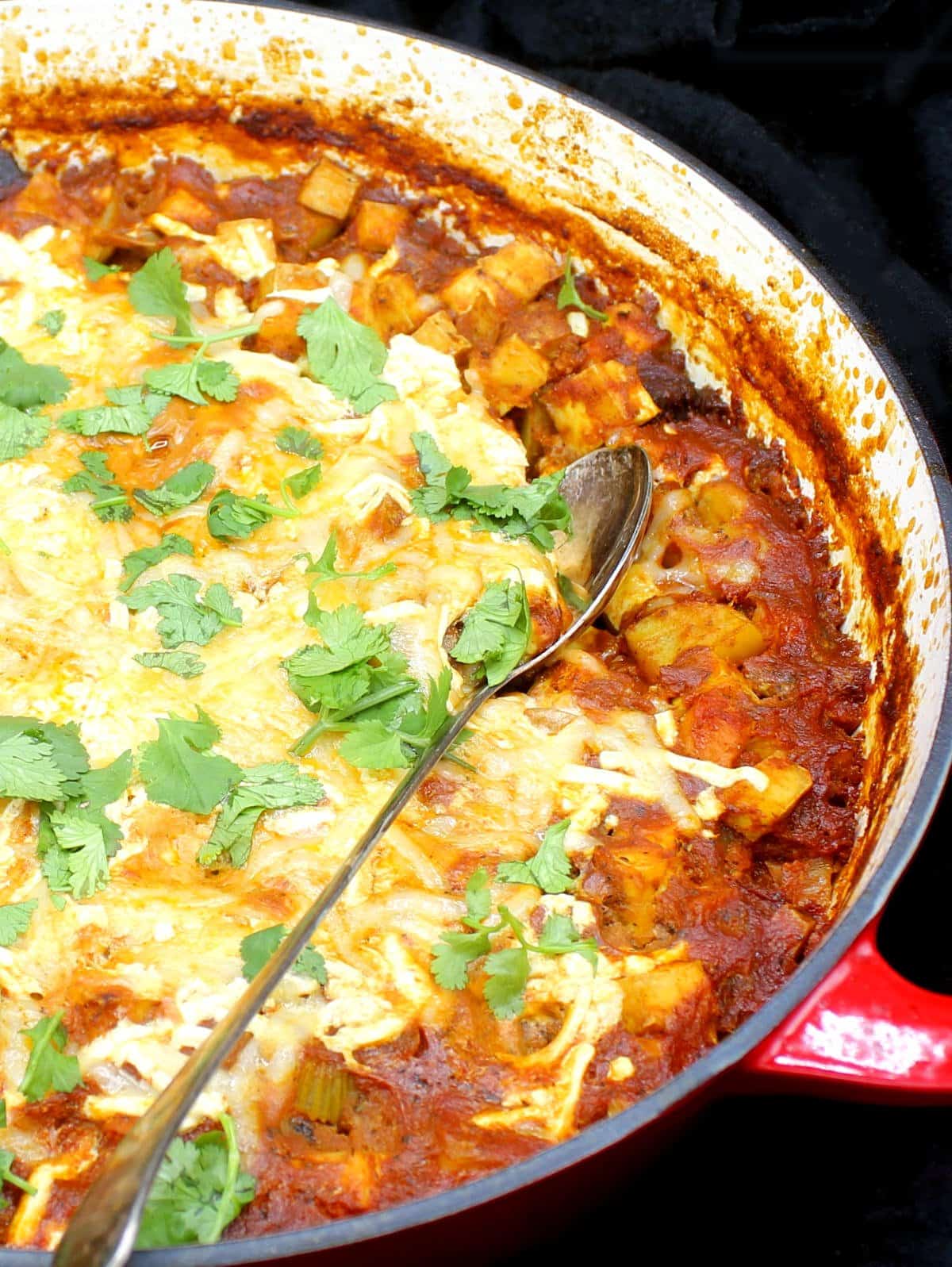 Best vegan Indian spiced tofu casserole in a skillet with a spoon. 