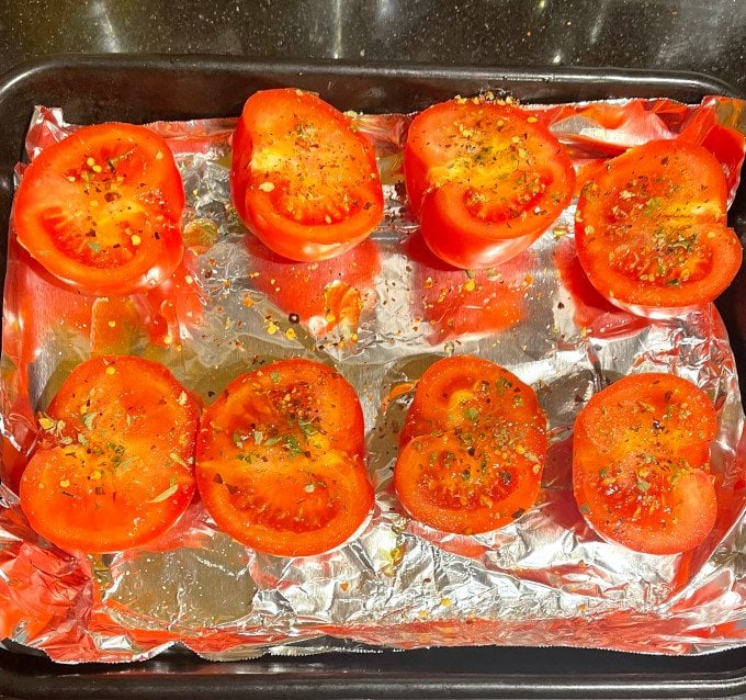 Tomatoes drizzled with olive oil, salt, pepper and Mexican oreganoin baking dish 