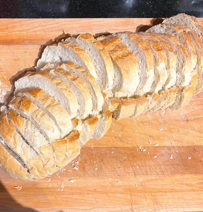 Sliced Italian bread on chopping board.