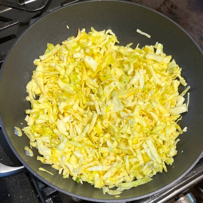 Cabbage curry sauteeing in wok.