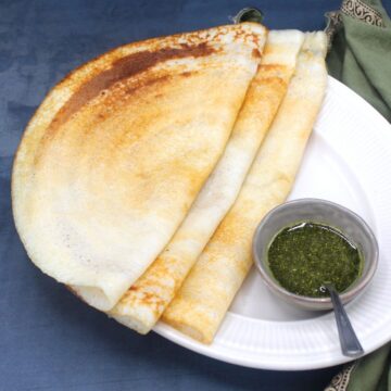 Image of three dosas on a plate with chutney.