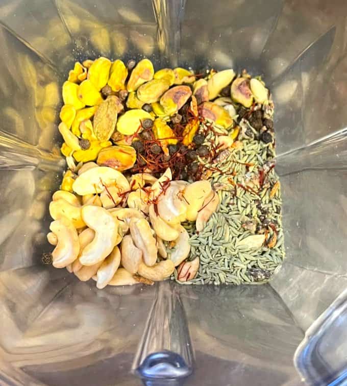 Ingredients for thandai masala in blender, including pistachios, cashews, fennel, saffron, almonds and more.