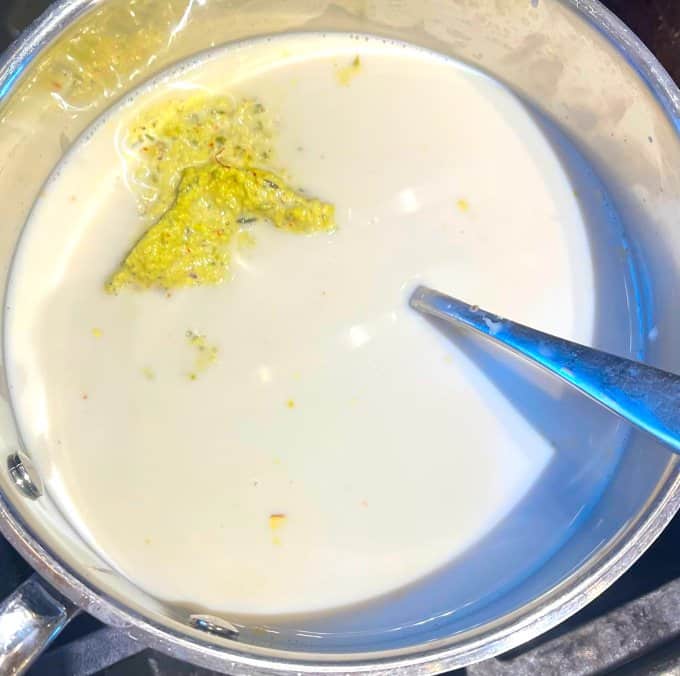 Oat milk on stove with thandai masala added to it.