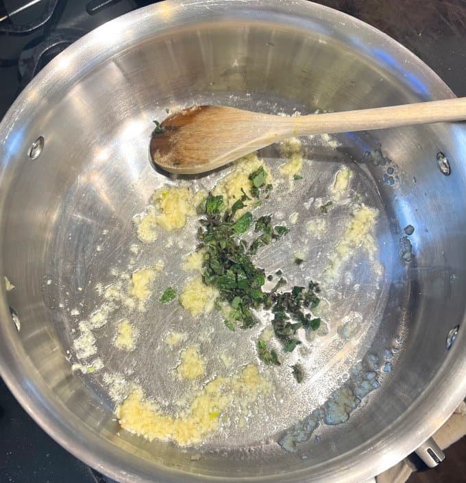 Oregano and garlic sauteing in pot.