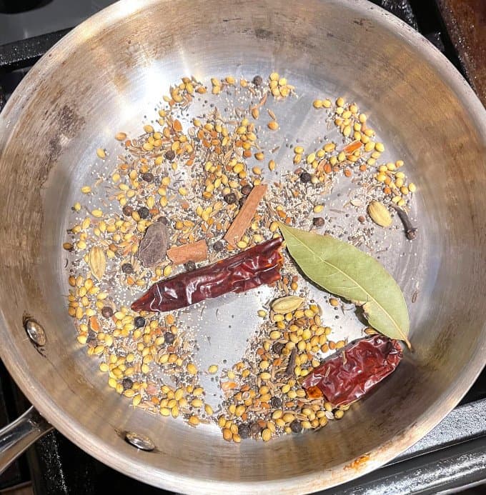 Dhansakh masala ingredients in skillet, roasting.